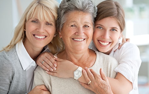 grandmother being embraced by her daughter and grandaughter