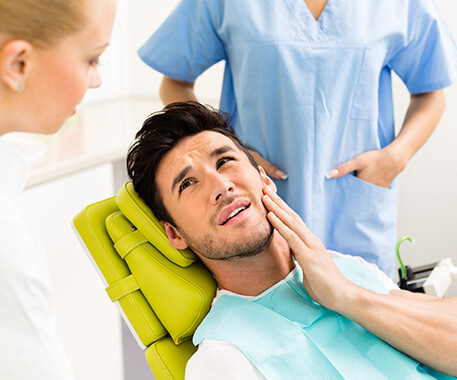 man holding his jaw in pain