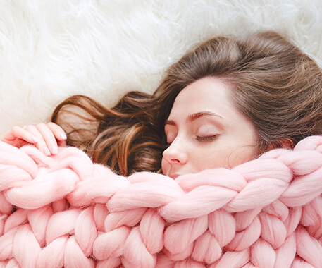 woman relaxing under a blanket