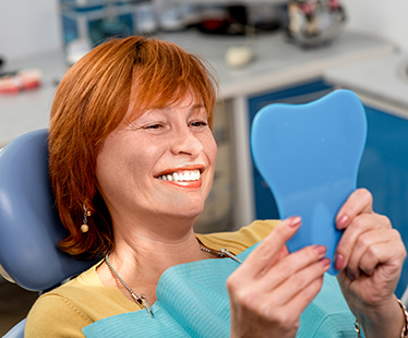 smiling woman looking at her teeth